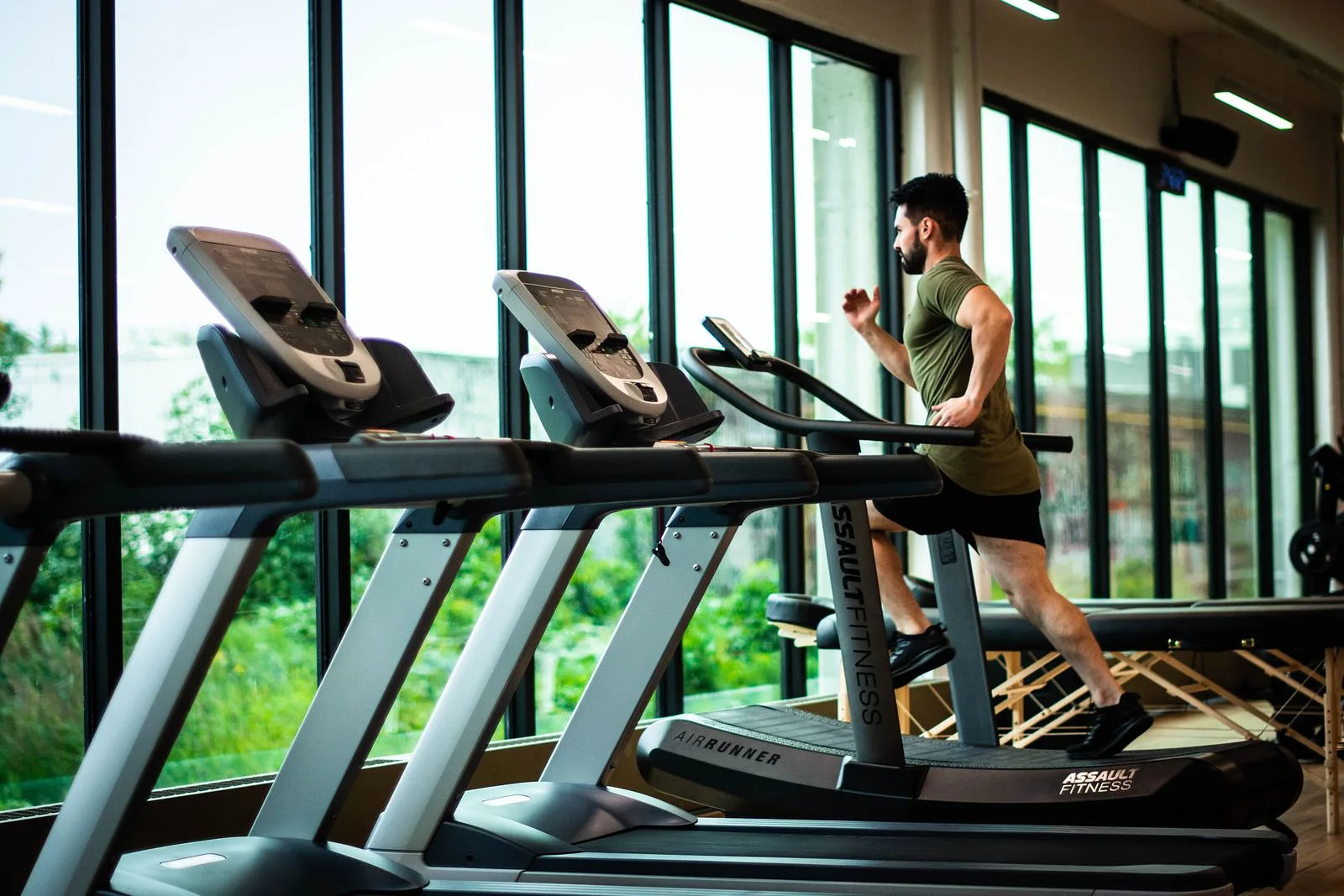 Runner training on a treadmill in a bright gym