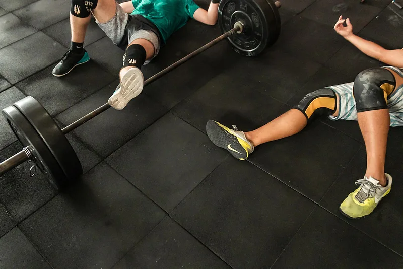 People resting after a heavy barbell exercise in the gym